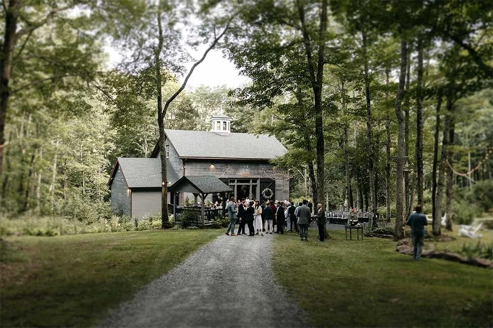  Roxbury Barn and Estate is set in Catskills Woods and is a beautifully curated wedding venue. One thing that is guaranteed is that you’ll have a unique and welcoming wedding celebration. I also love that the owners of this farm put so much work into making it a haven.  Roxbury Barn and Estate Offers 50 acres, multiple indoor and outdoor spaces, and modern amenities. You’ll also love the 170-year-old black-stained barn and other details like designer chandeliers, a bonfire, and even wifi.  This venue offers a spectacular pine forest for your beautiful wedding day photography. You can also use a manicured wooden arch that blends into the forest for your wedding ceremony altar. Are you planning an intimate and gorgeous Hudson Valley Farm wedding? Then Roxbury Barn and Estate might be the location for you.&nbsp; 