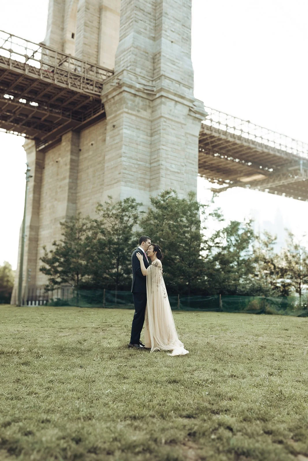  Brooklyn Bridge Park wedding portraits showcasing couple in golden hour light with Manhattan Bridge backdrop by wedding photographer 